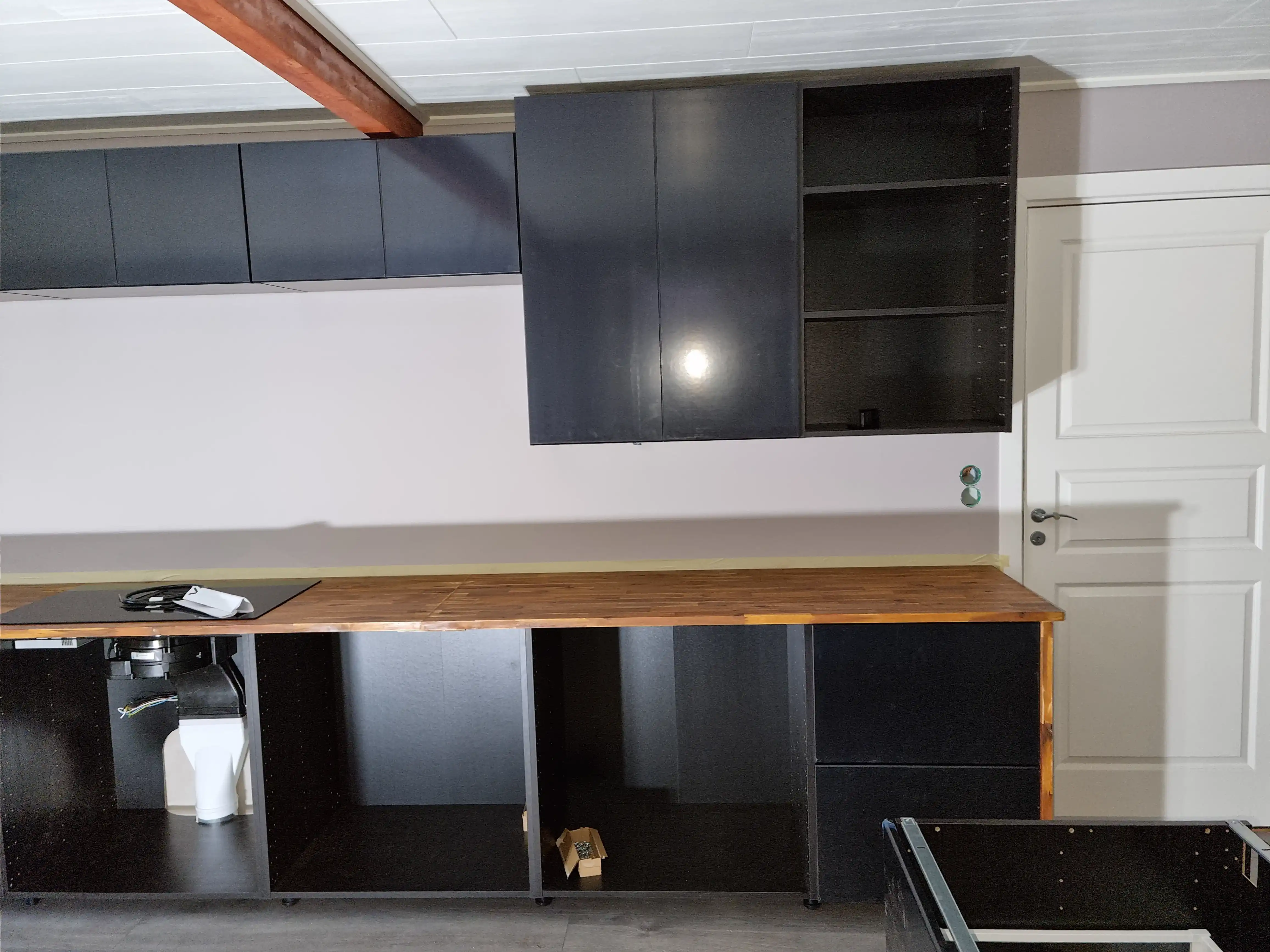 Stor köksrenovering med mörka toner och varma trädetaljer bild 3