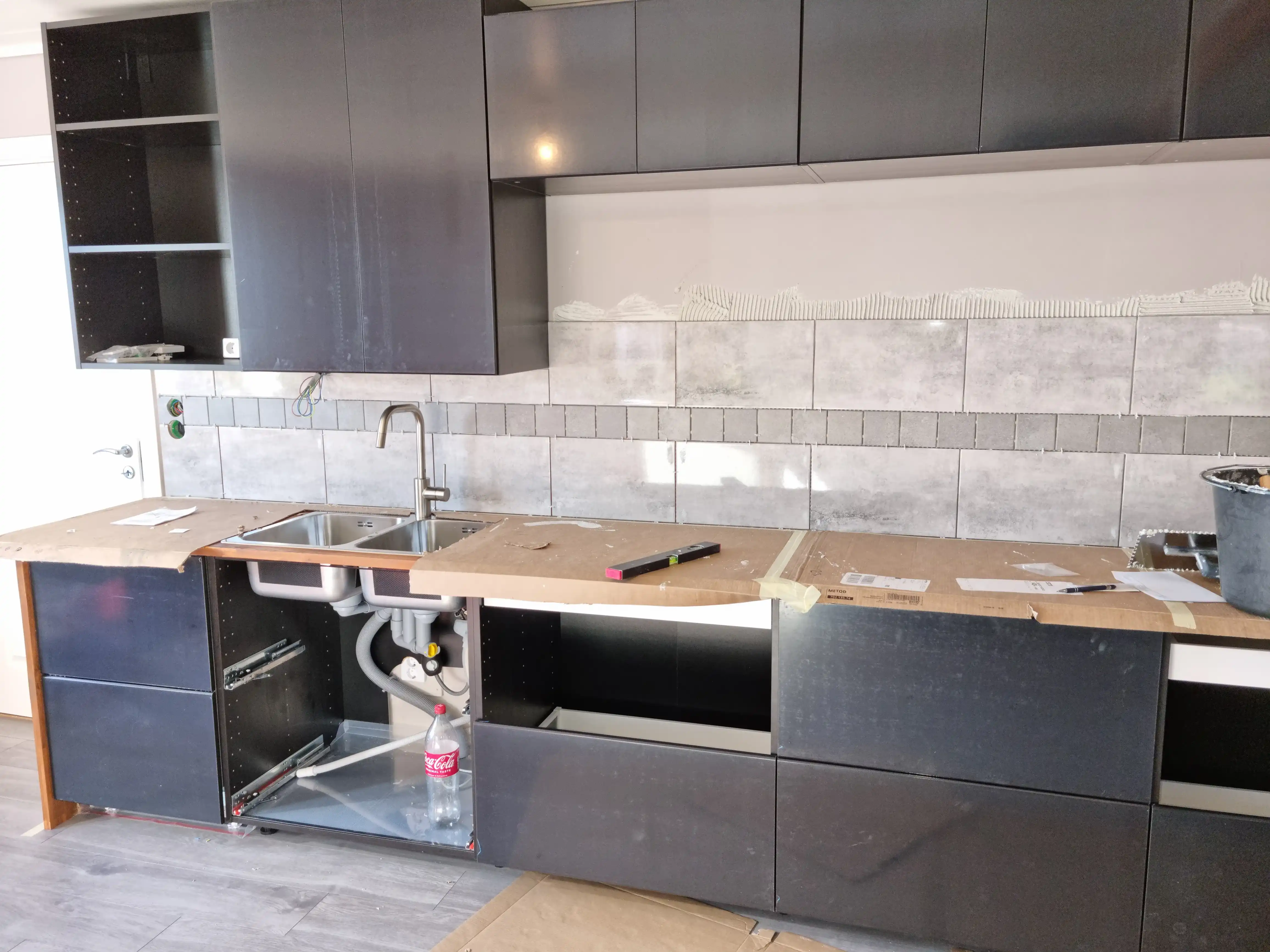 Stor köksrenovering med mörka toner och varma trädetaljer bild 1